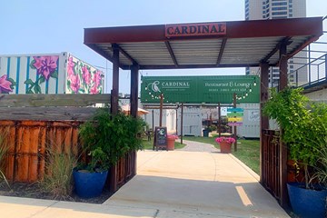 Cardinal Restaurant & Lounge outdoor walkway with gardens and decorative murals with flowers.