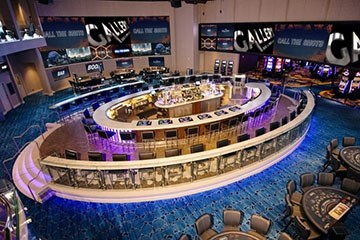 Gallery Bar Book and Games at Ocean Casino interior with center bar, tvs and tables for gambling.