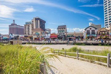 Beach entrance just off the boardwalk in Atlantic City with Boardwalk shops and Claridge Hotel in view.