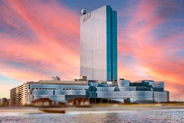 Ocean Casino Resort Atlantic City NJ with beach and ocean in foreground and wispy clouds giving a sunset vibe.