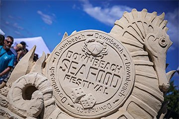Downbeach Seafood Festival Sand sculpture near tents set up for the festival.
