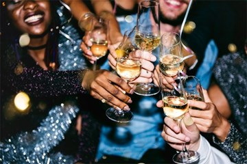A group of party goers toast with Champagne at an upscale event.