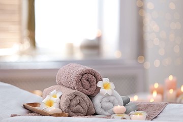 Towels rolled up with flowers and candles lit at a Day Spa in Atlantic City, NJ.