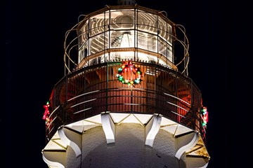 The top of the Absecon Lighthouse with lit up Wreath surrounding the walkway.