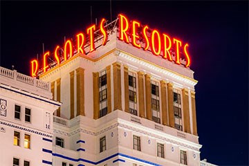 Resorts Neon sign at top of white and gold accented hotel tower in Atlantic City.